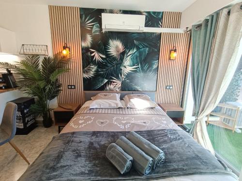 - une chambre avec un lit et des serviettes dans l'établissement Léman Holidays - Le Palm, à Mandelieu-la-Napoule