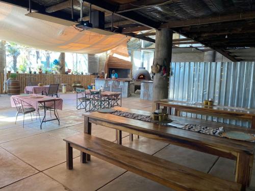a restaurant with wooden tables and chairs and a fireplace at Kappsfarm Guesthouse in Voigtland