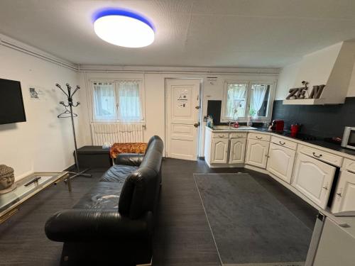 un salon avec un canapé et une cuisine dans l'établissement La demeure d'Iris, à Bougival