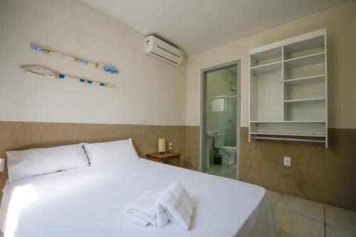 um quarto com uma grande cama branca e um espelho em Porto Paraty Residencial em Paraty