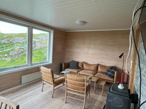 uma sala de estar com um sofá, uma mesa e cadeiras em Idyllic and peaceful Family Home em Tromsø