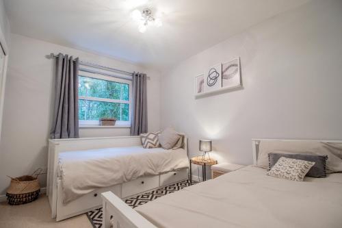 een slaapkamer met 2 bedden en een raam bij Garden View Nook-2 bed apartment in High Blantyre