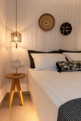 a bedroom with a white bed and a table at Juliano luxury apartments, port of Naxos in Naxos Chora