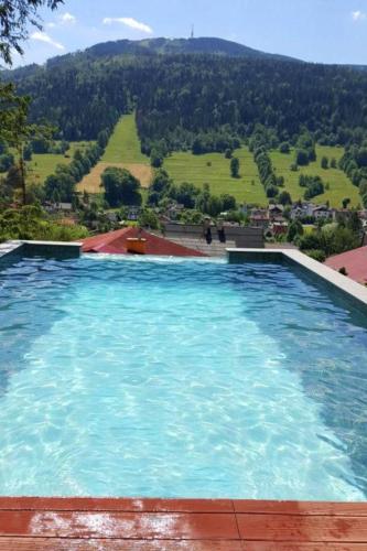 a large swimming pool with a view of a mountain at Willa Świerkowa 19 in Szczyrk