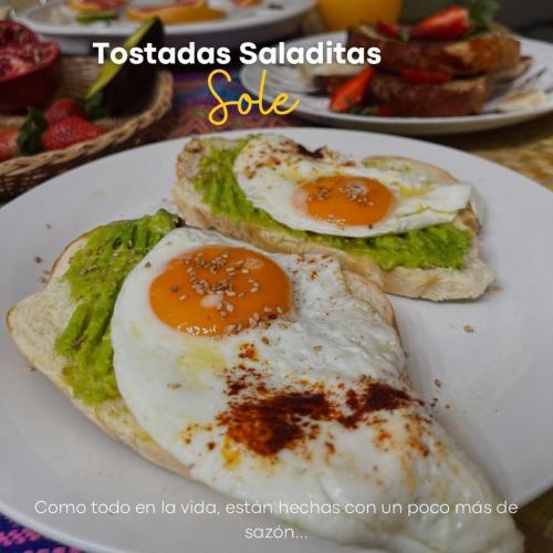 deux œufs au plat sur une assiette sur une table dans l'établissement Hostal Sole, à Santa Ana