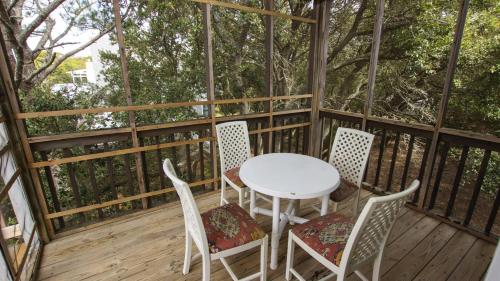 a table and chairs on a deck with trees at Soundfront, Priv Dock, Sound Views, Sun Deck, SA425, Sound Mind in Sanderling