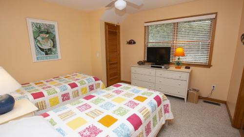 a bedroom with two beds and a flat screen tv at Soundfront, Priv Dock, Sound Views, Sun Deck, SA425, Sound Mind in Sanderling