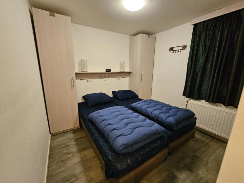 ein Schlafzimmer mit einem großen Bett mit blauen Kissen in der Unterkunft RBR 2465 - Beach Resort Kamperland in Kamperland