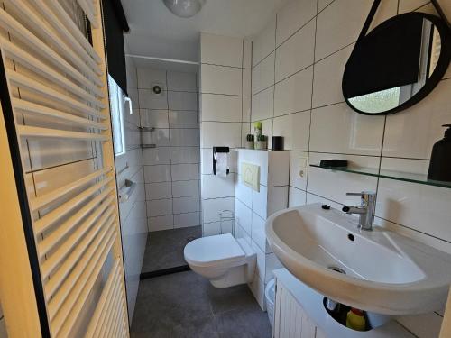 ein Bad mit einem Waschbecken und einem WC in der Unterkunft RBR 2465 - Beach Resort Kamperland in Kamperland