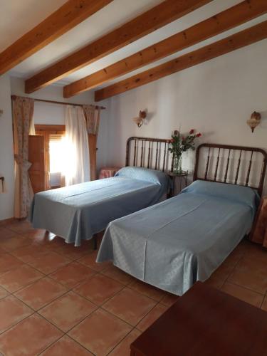 two beds sitting in a room with at Casa Rosa in Alcalalí