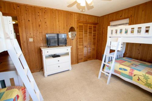 a bedroom with two bunk beds and a television at OCEANFRONT, Ocean views, Quiet area, SA183, Ocean Island in Sanderling
