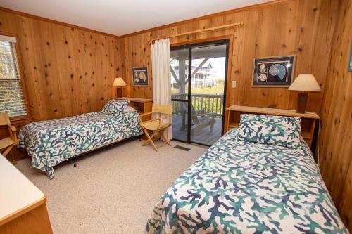 une chambre avec deux lits et un balcon dans l'établissement Semi-Oceanfront, secluded Beach Cottage, Close to Beach! SA210, Farmer, à Sanderling