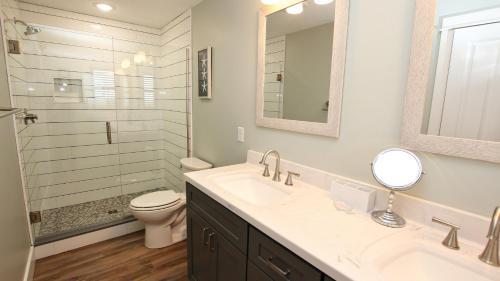 La salle de bains est pourvue d'un lavabo, de toilettes et d'un miroir. dans l'établissement SA69, Kirk- Oceanfront, Ocean Views, Sun Decks, Prv Beach Access, à Sanderling