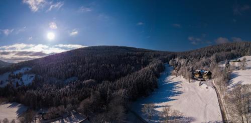 an aerial view of a snow covered mountain with a river at Svycarska Bouda in Špindlerův Mlýn