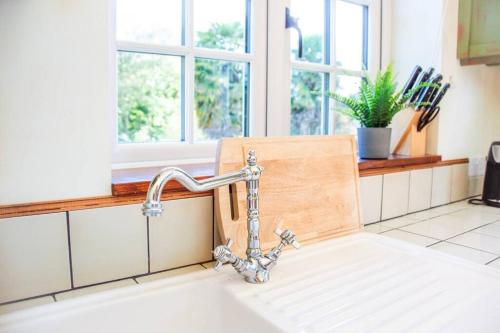 a kitchen sink with a faucet in a kitchen at The Snug, Beautiful Country Retreat in Priston