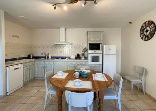 une cuisine avec une table en bois et des appareils électroménagers blancs dans l'établissement Laubaret, à Loubieng