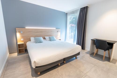 a hotel room with a bed and a desk and a window at Kyriad Résidence Cabriès - Plan de Campagne in Cabriès