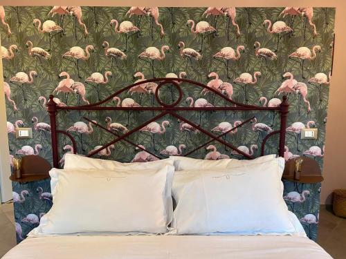 a headboard of a bed with a pink flamingo wallpaper at VILLA ADRIANA in Bra