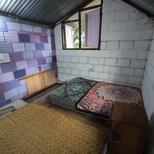 a room with two beds in a brick wall at Morada Al Sur in Mocoa