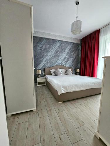 een slaapkamer met een bed en een rood gordijn bij Sunrise Residence in Mamaia Nord – Năvodari