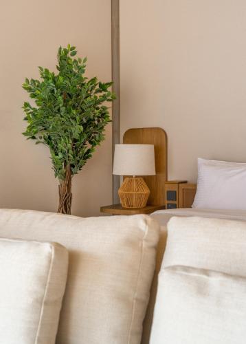 a bedroom with two beds and a table with a plant at Pura Eco Retreat, Jebel Hafit Desert Park in Al Ain
