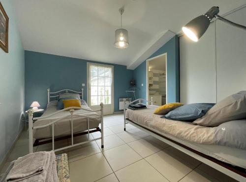 2 Betten in einem Schlafzimmer mit blauen Wänden in der Unterkunft Lassegues in Castetner