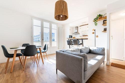 un salon avec un canapé, une table et des chaises dans l'établissement 4 personnes - 2 chambres -fibre - balcon - confort, à Grenoble