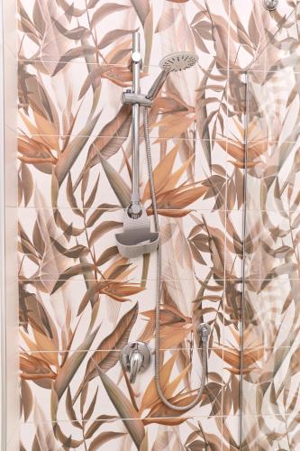 a shower in a bathroom with a mural of leaves at Hotel Melydà in Pozzuoli