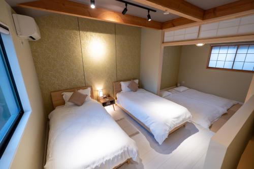 una piccola camera con due letti di 【Kyoto 幸】東寺まで１分、京都駅から15分！立地が便利な丸ごと貸し切る一軒家 a Kyoto