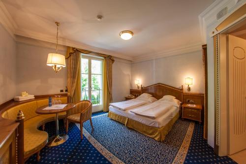 a bedroom with a bed and a desk and a table at Cityhotel Goldener Adler B&B in Chiusa