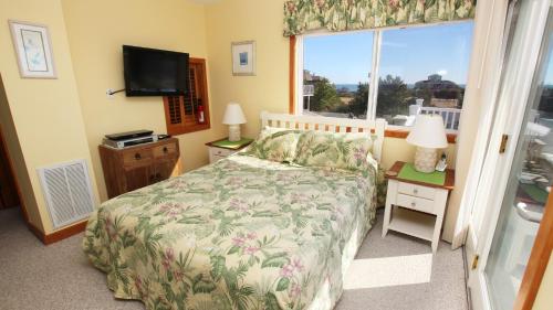 a bedroom with a bed and a window at Oceanside, Ocean and Sound Views, Sun Decks, Rec Rm, SEA12, Farrview in Duck