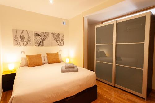 a bedroom with a bed with two lamps and a closet at Piso con dos dormitorios frente a Plaza Mayor in Madrid