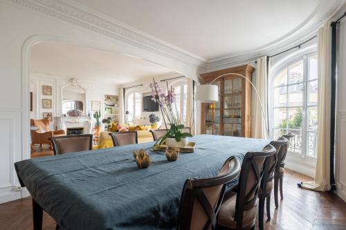 une salle à manger avec une table et des chaises bleues dans l'établissement Veeve - Sunrise Synergy, à Paris