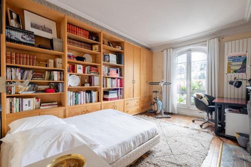 - une chambre avec un lit, un bureau et des étagères dans l'établissement Veeve - Sunrise Synergy, à Paris