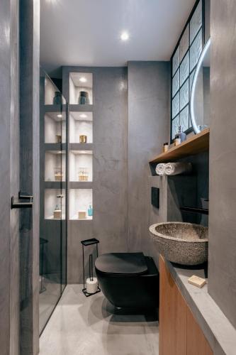 La salle de bains est pourvue de toilettes noires et d'un lavabo. dans l'établissement Veeve - Sunrise Synergy, à Paris