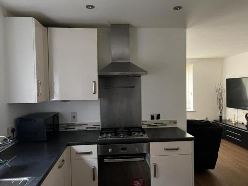 a kitchen with white cabinets and a stove top oven at Immaculate 1-Bed Apartment in East London in London