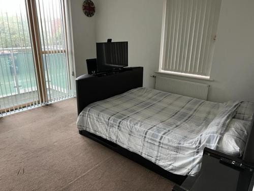 a bedroom with a bed and a flat screen tv at Immaculate 1-Bed Apartment in East London in London
