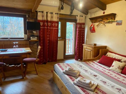 a bedroom with a bed and a desk and a table at Il nocciòlo di Daisy in Graglia