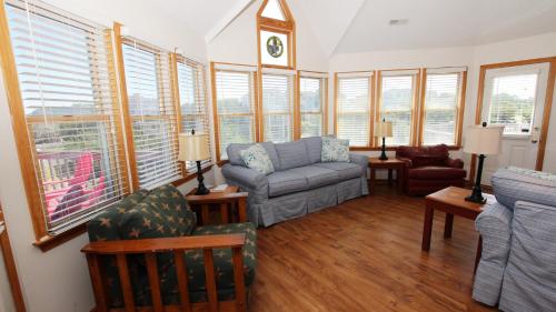 a living room with a couch and chairs and windows at Oceanside, Private Pool, Community Pool, Sun Deck, SP8, Ole Duck Haven in Duck