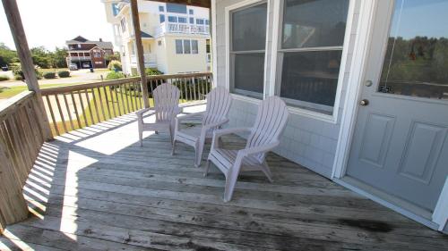 a porch with three chairs and a door at Oceanside, Private Pool, Community Pool, Sun Deck, SP8, Ole Duck Haven in Duck