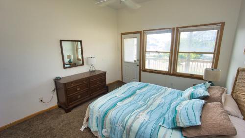 a bedroom with a bed and a dresser and a mirror at Oceanside, Private Pool, Community Pool, Sun Deck, SP8, Ole Duck Haven in Duck