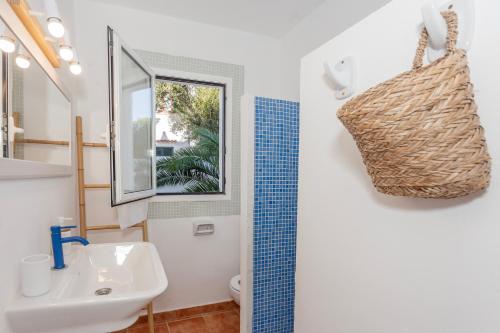 a bathroom with a sink and a toilet and a window at Apartamento con patio in Cala Santandria