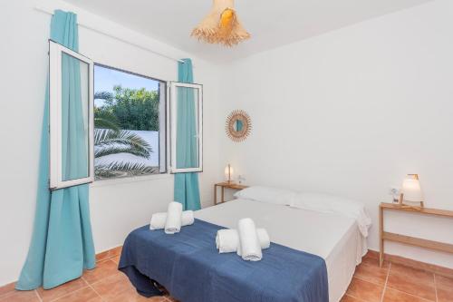 1 dormitorio con 1 cama y 2 ventanas en Apartamento con patio en Cala Santandria