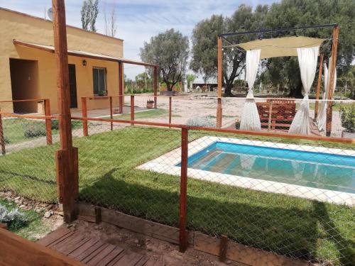 a villa with a pool and a house at Cabañas mi Terruño in San Rafael