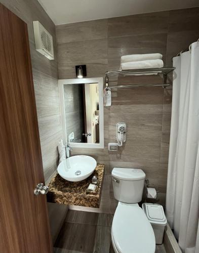 a bathroom with a toilet and a sink and a mirror at Rado Hotel - Quintanas in Trujillo