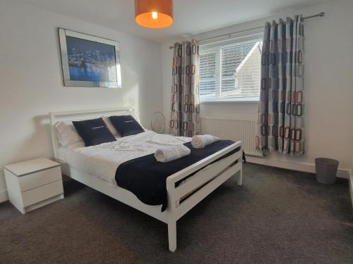 a bedroom with a bed and a window at 3 bedroom modern house. Merthyr Tydfil near bike park wales and Brecon Beacons National park in Dowlais