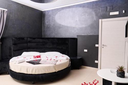 a bedroom with a large bed with a black wall at Hotel Melydà in Pozzuoli