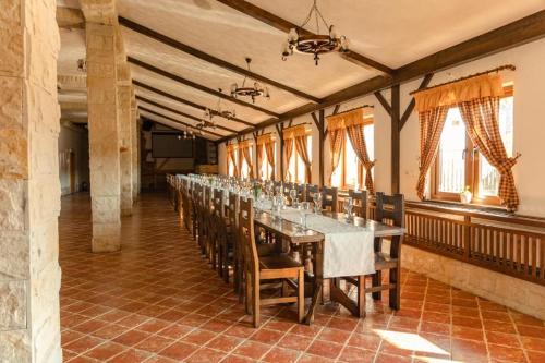 a long dining room with a long table and chairs at Pensiunea Landhof Apfel Mayr in Bazna