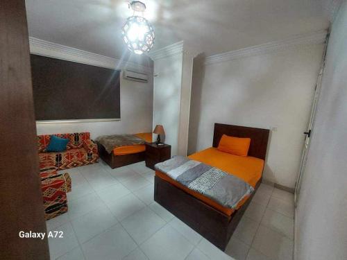 sypialnia z 2 łóżkami i tablicą na ścianie w obiekcie شقة على النيل في البحر الاعظم w Kairze