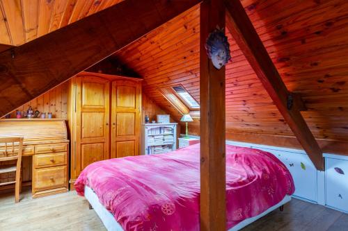 a bedroom with a pink bed in a wooden cabin at Maison mitoyenne proche lac annecy in Annecy-le-Vieux